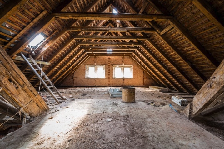 Unfinished attic space in a New Jersey home showing exposed rafters, insulation gaps and open flooring, often evaluated before installing an HVAC system.